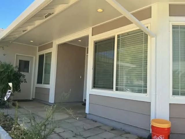 Tan exterior repaint with white porch columns and beams