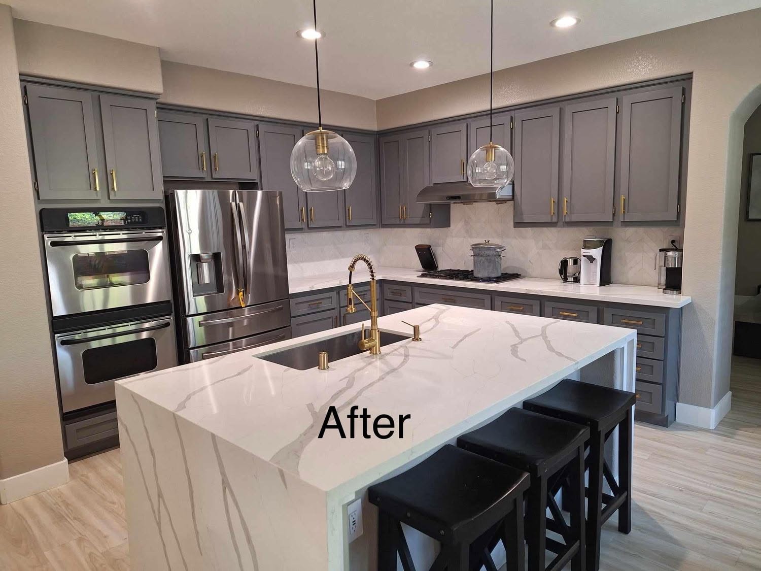 Refinished gray kitchen cabinets with white marble island