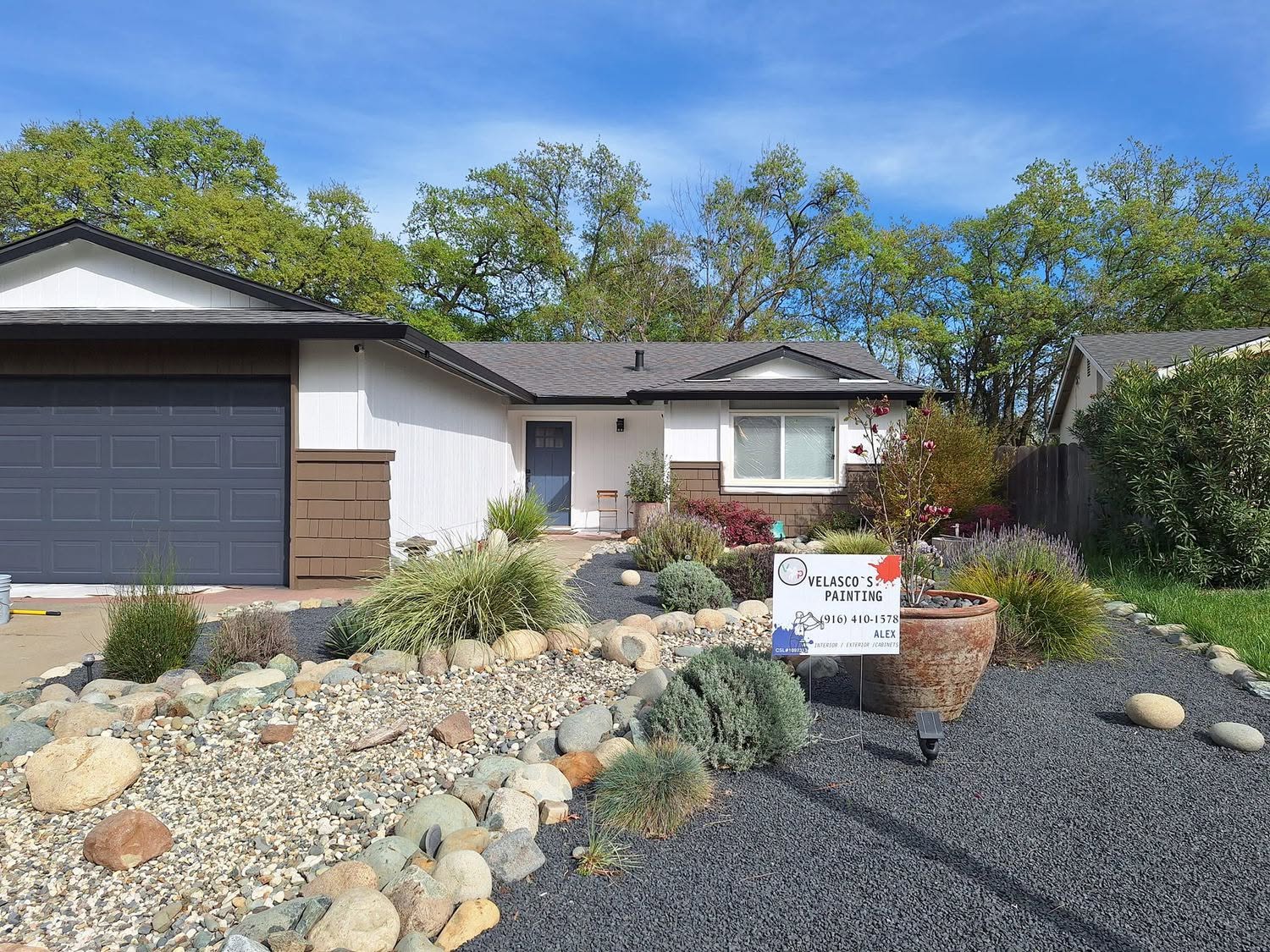 Crisp white ranch home with dark charcoal garage door