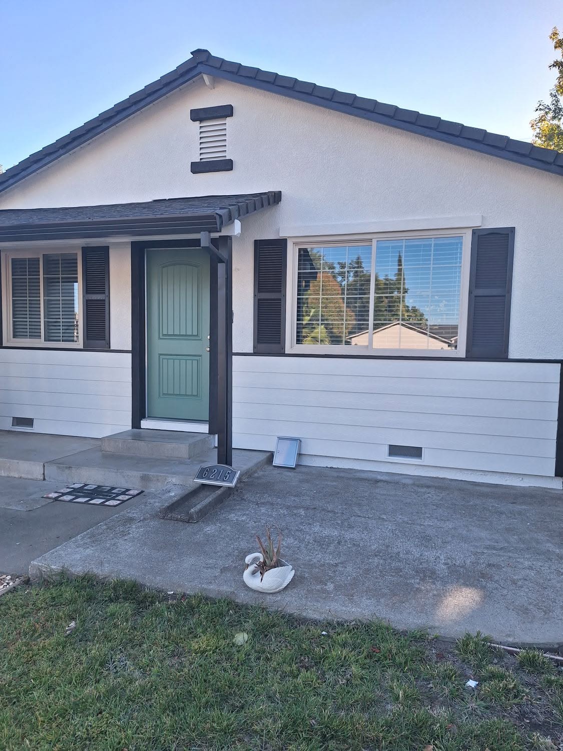 White bungalow exterior repaint with sage green front door