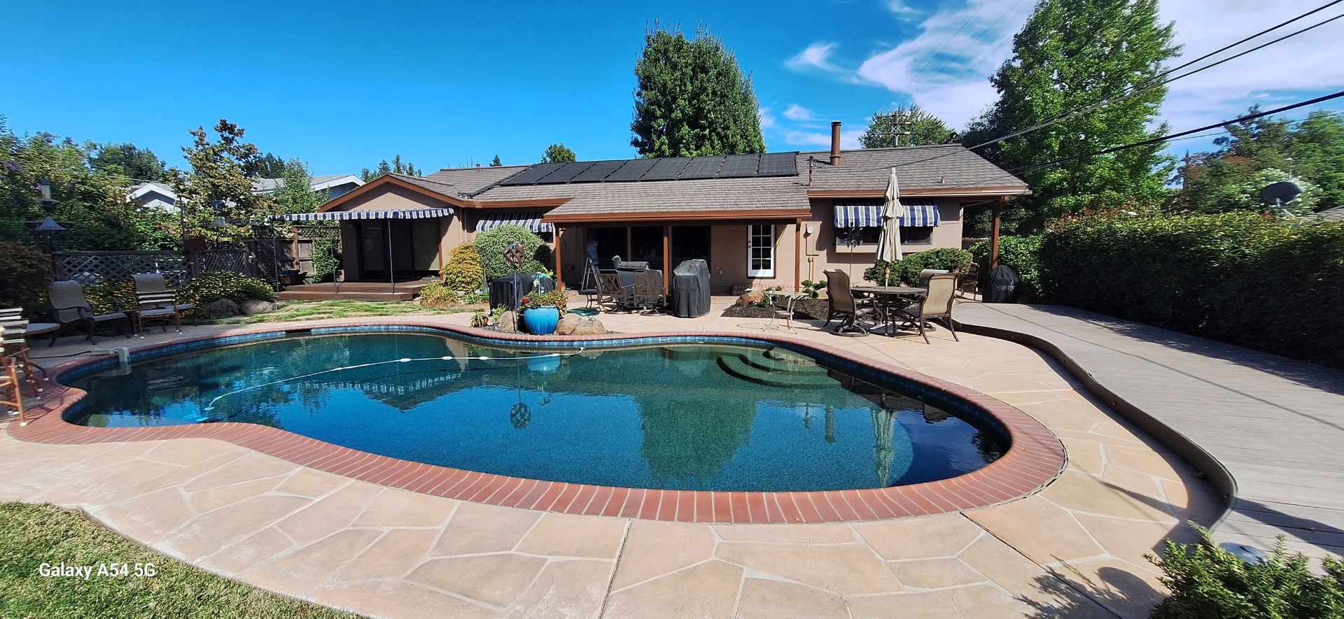 Warm neutral exterior repaint on backyard pool home