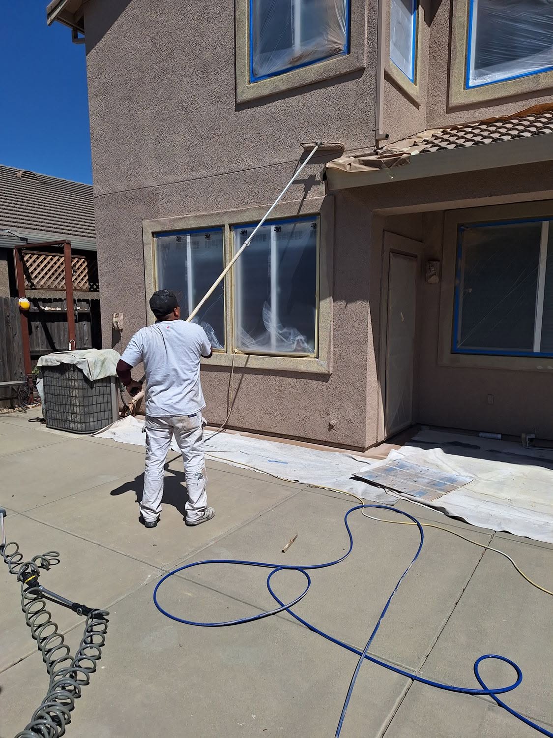 Velasco's Painting crew masking and spraying a stucco exterior